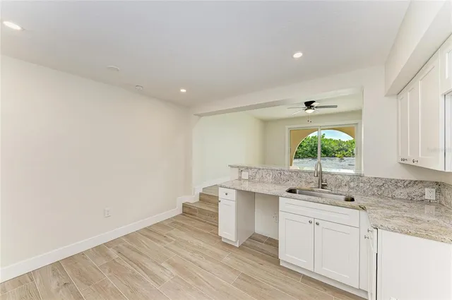 a kitchen with white cabinets and refrigerator