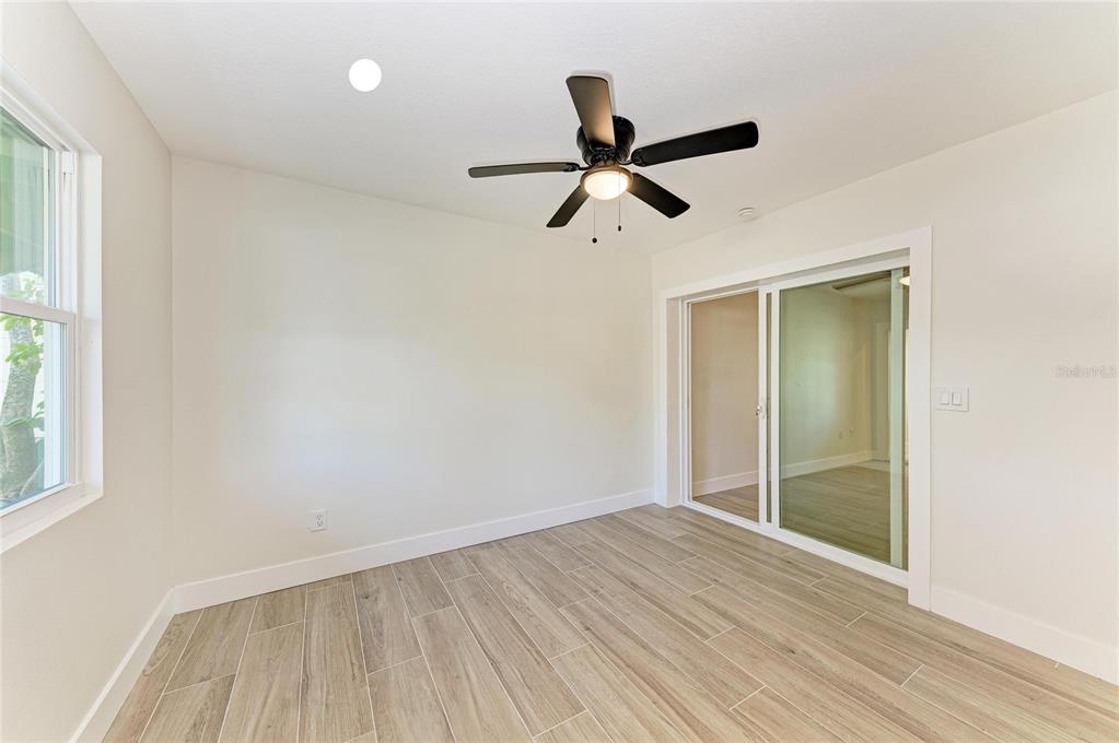 101 73rd Street, Unit 2 Holmes Beach, FL 34217 - Photo 32 of 55 a view of empty room with wooden floor and fan