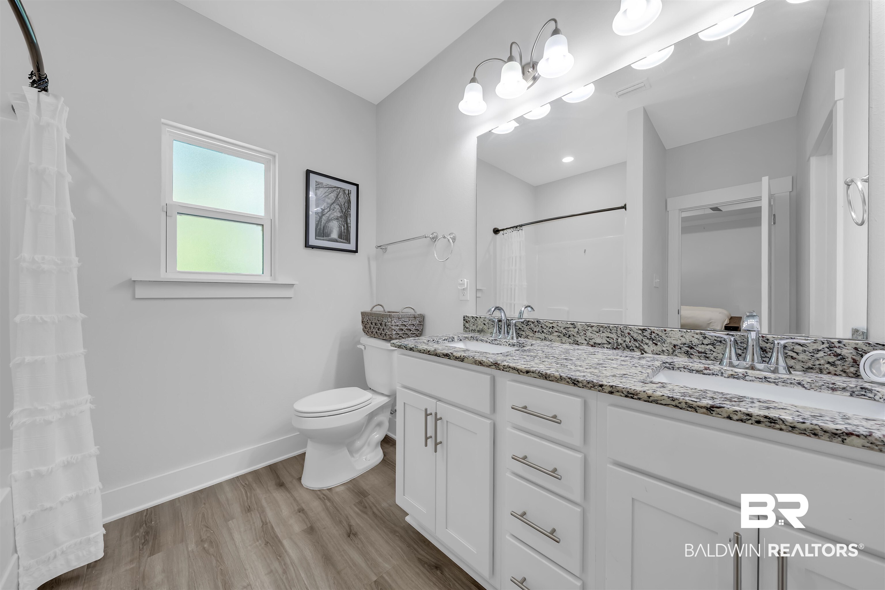 16504 Prado Loop Loxley, AL 36551 - Photo 28 of 45 Bathroom featuring double vanity, light wood-type flooring, ensuite bath, and a shower with curtain