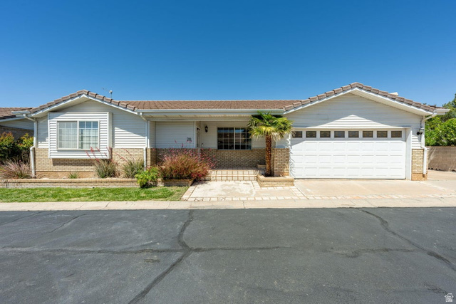 1040 East 900 South, Unit 28 St. George, UT 84790 - Photo 1 of 1 Ranch-style home featuring covered porch, a tiled roof, brick siding, and a garage