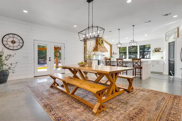 a living room with dining table and a chandelier