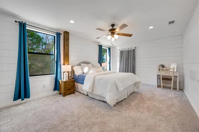 a spacious bedroom with a bed and a chandelier