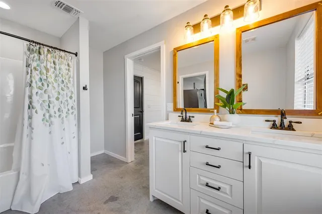 a bathroom with a double vanity sink mirror and shower