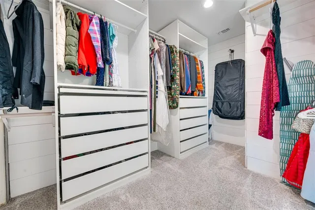 a view of walk in closet with clothes and shoes