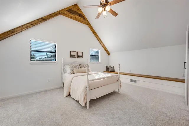 a spacious bedroom with a bed and a chandelier