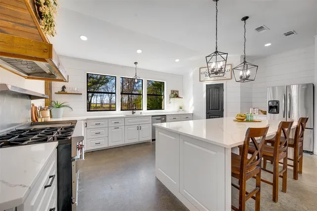 a kitchen that has a lot of cabinets a sink and a stove