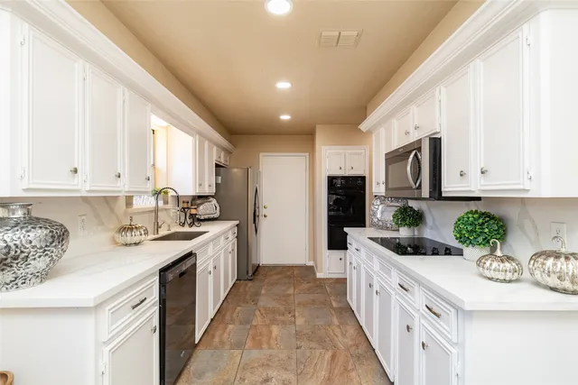 a kitchen with stainless steel appliances granite countertop a sink and cabinets