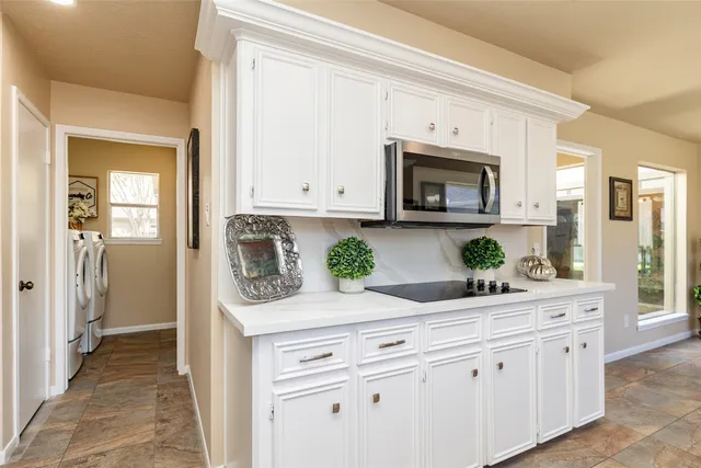 a kitchen with granite countertop white cabinets and white appliances
