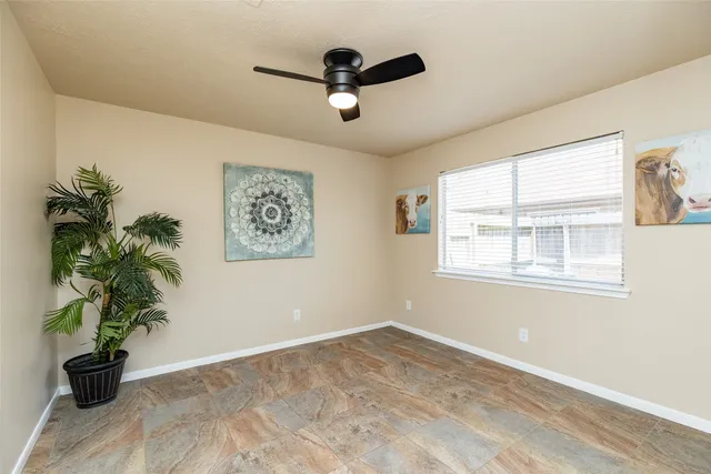 a view of empty room with wooden floor and potted plant