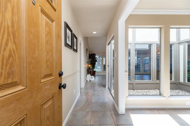 a view of a hallway with wooden floor and windows