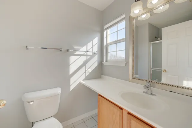 a bathroom with a sink a toilet a large mirror and shower