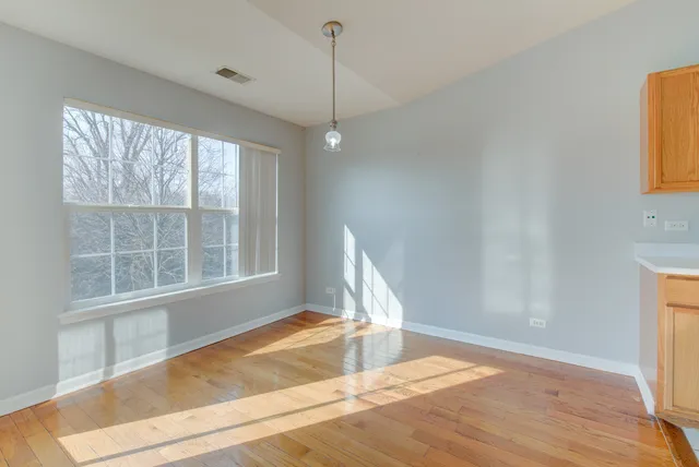a view of a room with a window and wooden floor