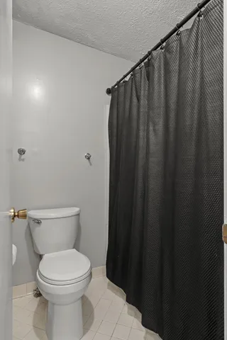 a white toilet sitting next to a shower curtain