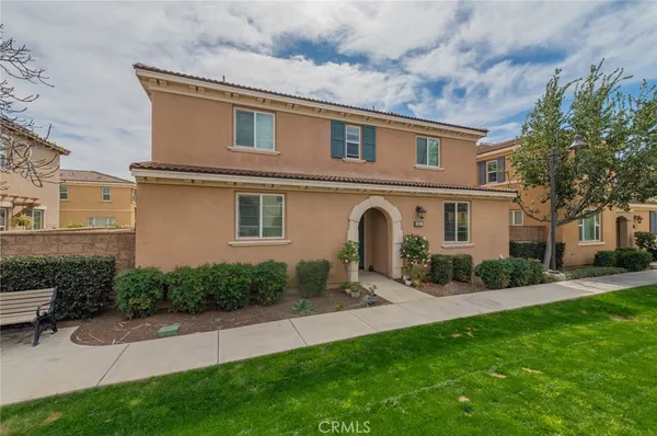 a front view of a house with a garden and plants