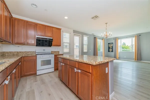 a kitchen with granite countertop cabinets stainless steel appliances and wooden floor