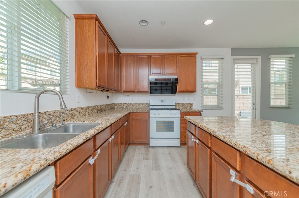 9361 Culinary Rancho Cucamonga, CA 91730 - Photo 24 of 45 a kitchen with kitchen island granite countertop a sink stove and cabinets