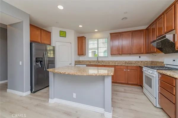 a kitchen with stainless steel appliances granite countertop a stove a sink and a refrigerator