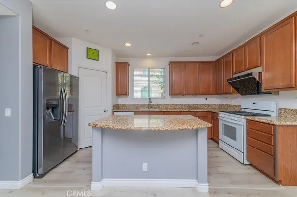 a kitchen with stainless steel appliances granite countertop a stove a refrigerator and a sink