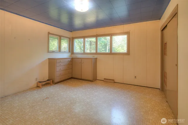 a view of an empty room with shelves and a window