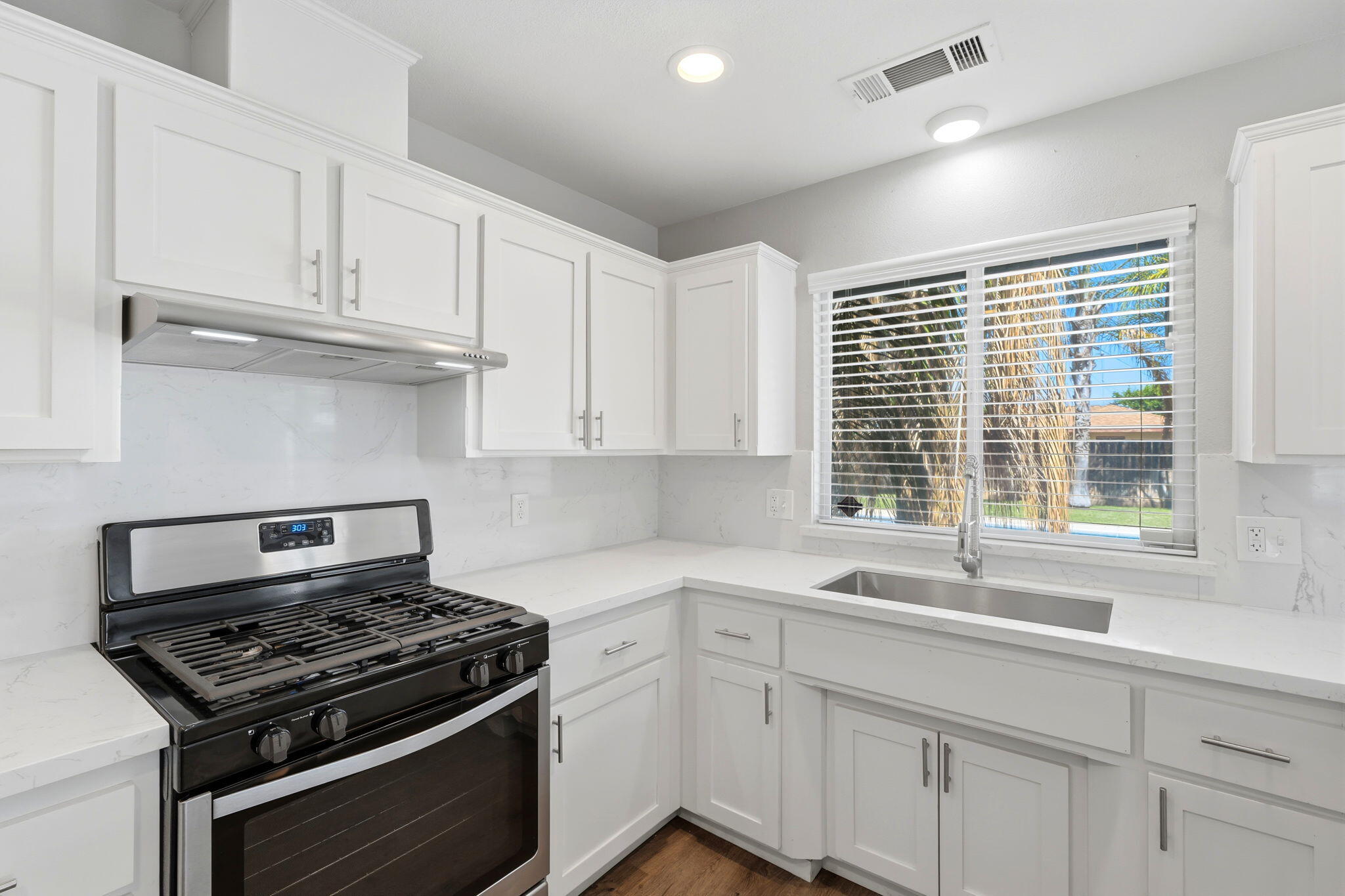481 Katelyn Court Exeter, CA 93221 - Photo 27 of 33 a kitchen with white cabinets and a stove top oven