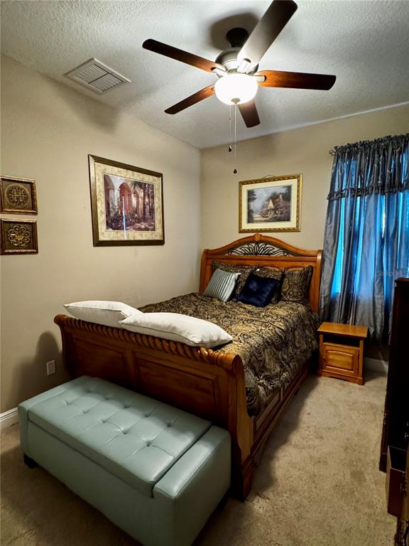 12419 Betony Court New Port Richey, FL 34654 - Photo 16 of 24 a bedroom with a bed and a chandelier