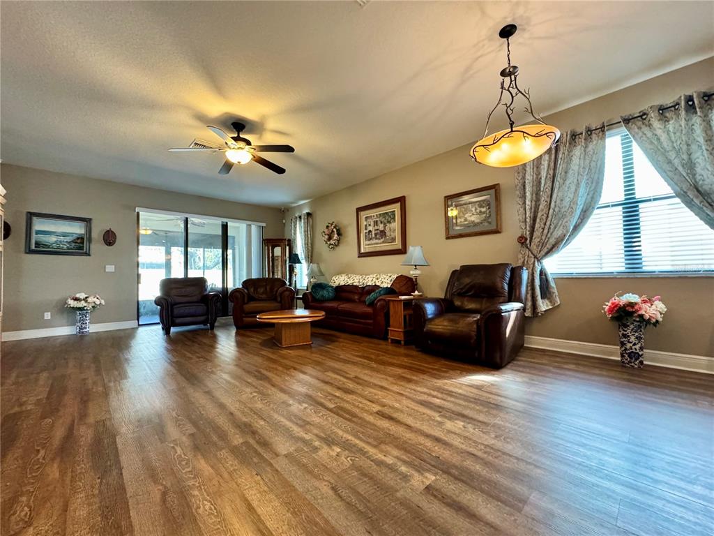 12419 Betony Court New Port Richey, FL 34654 - Photo 4 of 24 a living room with furniture a chandelier and a fireplace