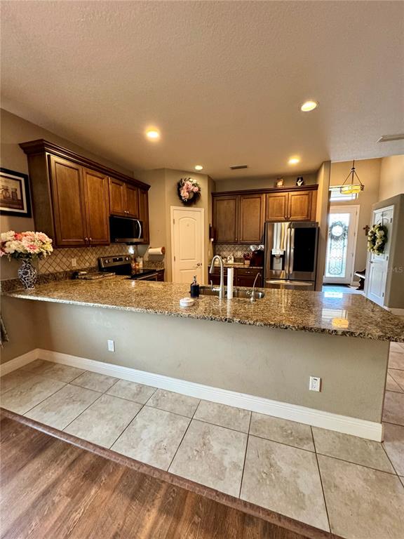 12419 Betony Court New Port Richey, FL 34654 - Photo 9 of 24 a view of kitchen with stainless steel appliances granite countertop a sink stove and cabinets