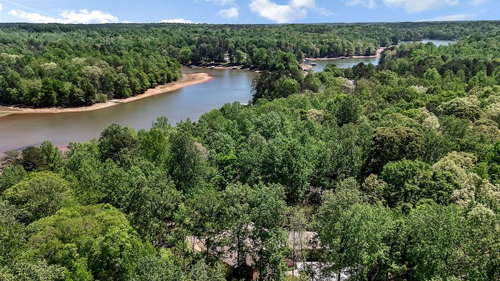 402 Boaters Row Fair Play, SC 29643 - Photo 43 of 50 This elevated view captures a serene lake winding through a verdant landscape under a bright sky.