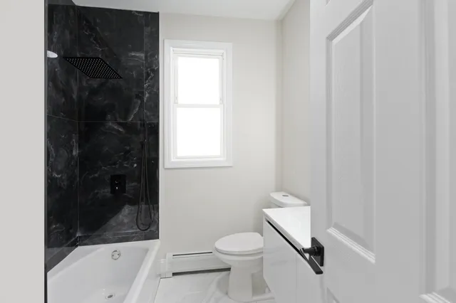 a bathroom with a toilet and a shower