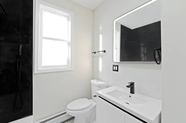 a kitchen with granite countertop white cabinets and black appliances