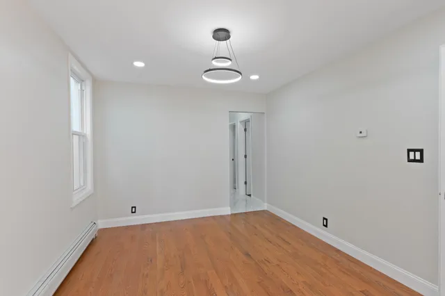 a view of a room with wooden floor and white walls