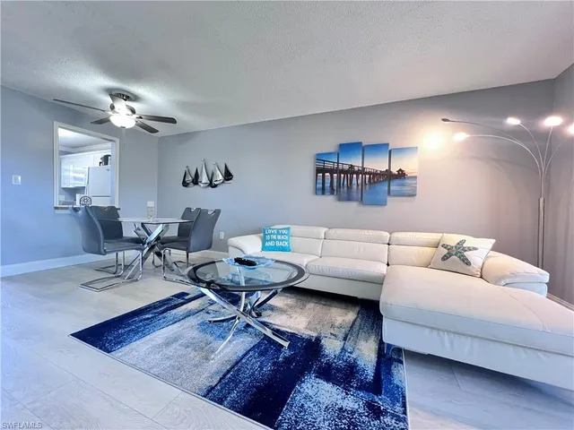 a living room with furniture a wall paintings and a window