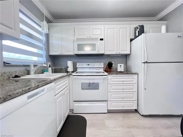 a kitchen with white cabinets and white appliances