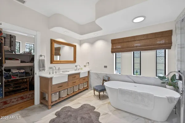 a spacious bathroom with a double vanity sink large mirror and a bathtub