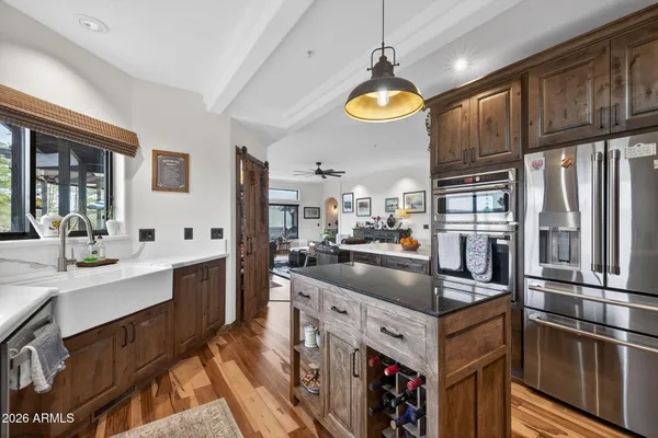 a kitchen with stainless steel appliances granite countertop a sink a stove and a refrigerator