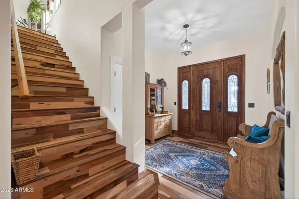 a view of a hallway with wooden floor and staircase
