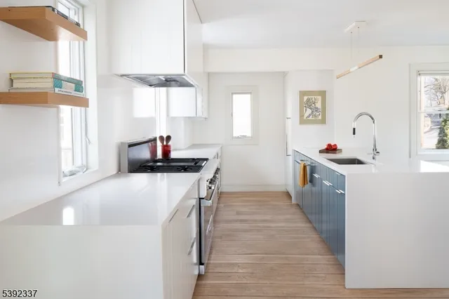 a kitchen that has a lot of cabinets and a wooden floor