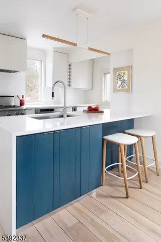 a kitchen with a sink cabinets and wooden floor
