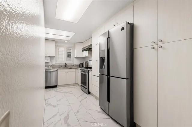 a bedroom with a bed and a flat tv screen on a dresser
