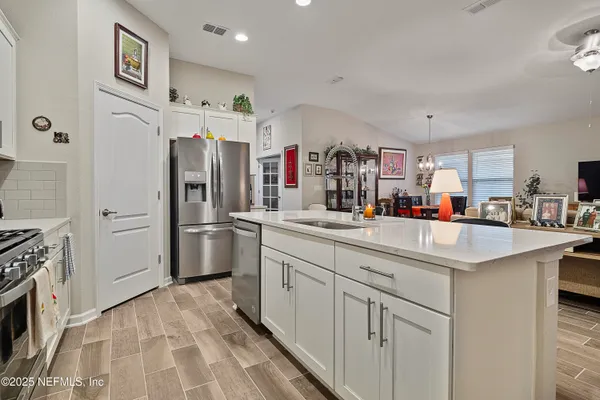 a kitchen with white cabinets and refrigerator