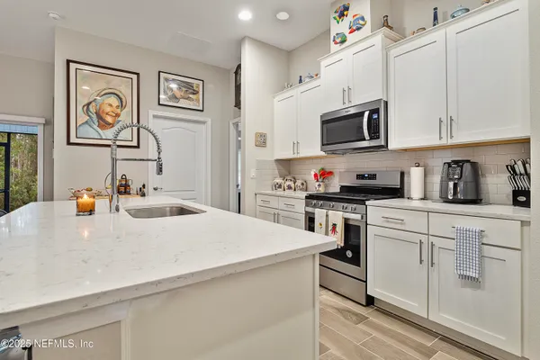 a kitchen with stainless steel appliances white cabinets and a sink