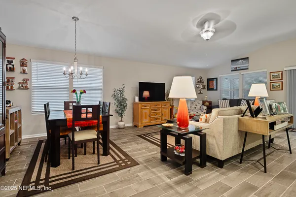 a living room with furniture a dining table and a chandelier