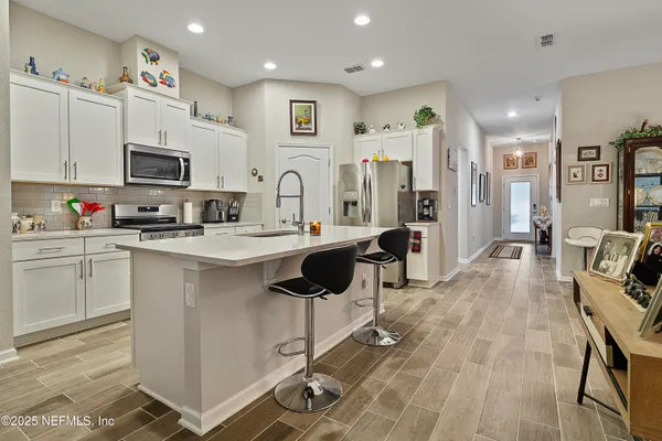 a kitchen with stainless steel appliances kitchen island granite countertop a refrigerator and microwave
