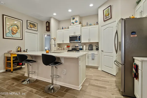 a kitchen with white cabinets and stainless steel appliances
