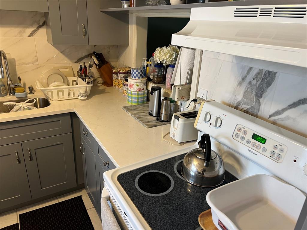 3140 Holiday Springs Boulevard, Unit 109 Margate, FL 33063 - Photo 6 of 26 a kitchen with a sink and a stove with wooden floor