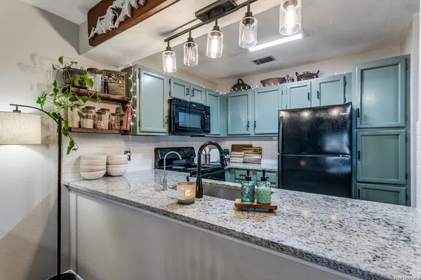 a kitchen with stainless steel appliances granite countertop a sink a stove and a refrigerator