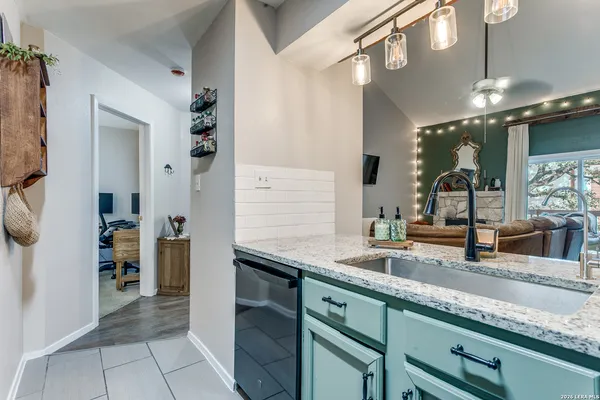 a kitchen with stainless steel appliances granite countertop a sink and a refrigerator