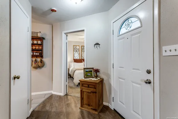 a view of a hallway with wooden floor closet and windows