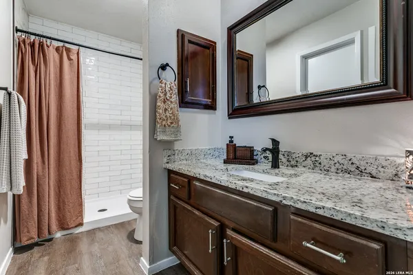 a bathroom with a granite countertop sink and a mirror
