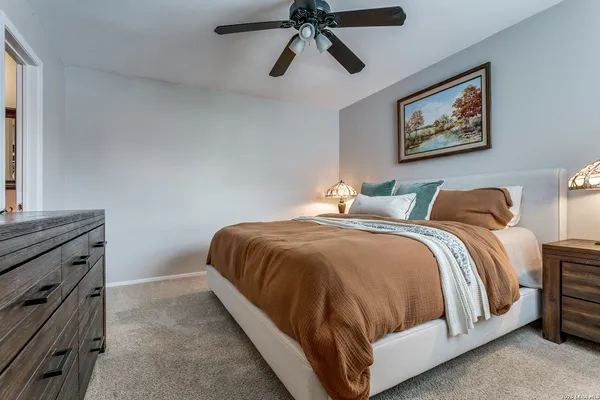 a bedroom with a bed and ceiling fan
